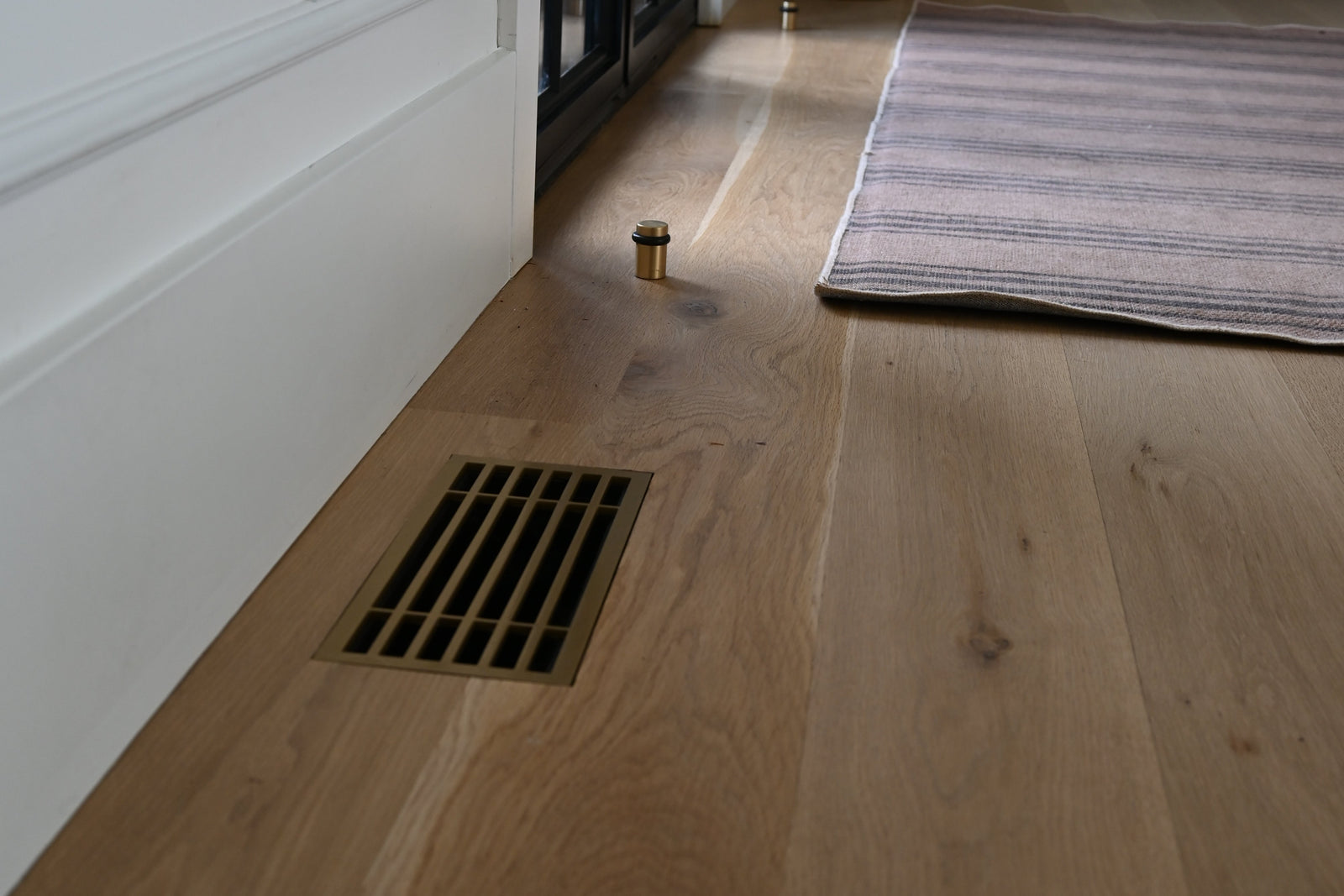 Bar · Vintage Gold flush floor vent in a wood floor