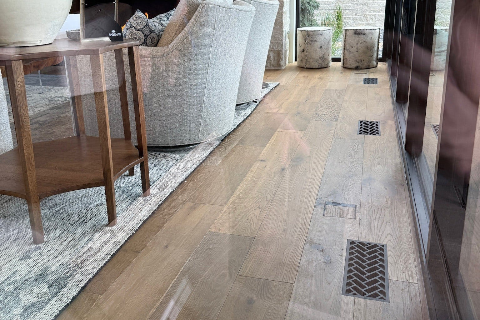 Herringbone · Matte Bronze flush floor vent in a wood floor