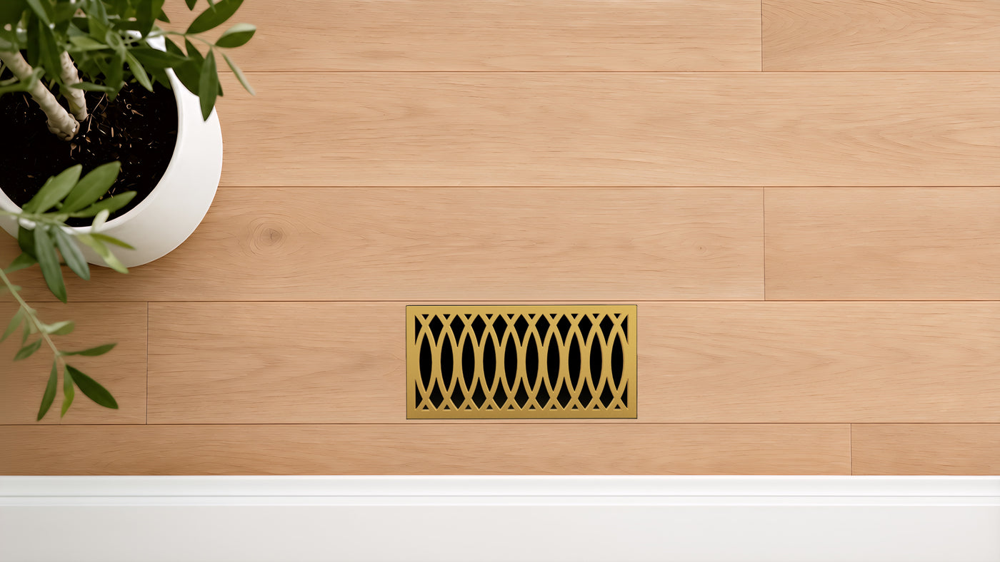 Curved · Vintage Gold flush floor vent in a wood floor