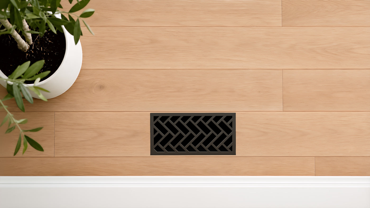 Herringbone · Matte Bronze flush floor vent in a wood floor